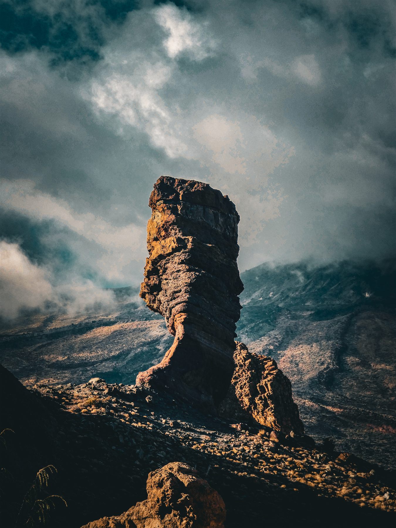 Roche volcanique dressée sous un ciel d'orage, parc national du Teide
